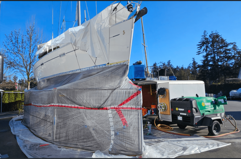 Sandblasting sailboat hull for marine paint removal and surface preparation